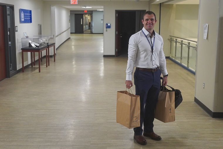 A man holding two bags of books